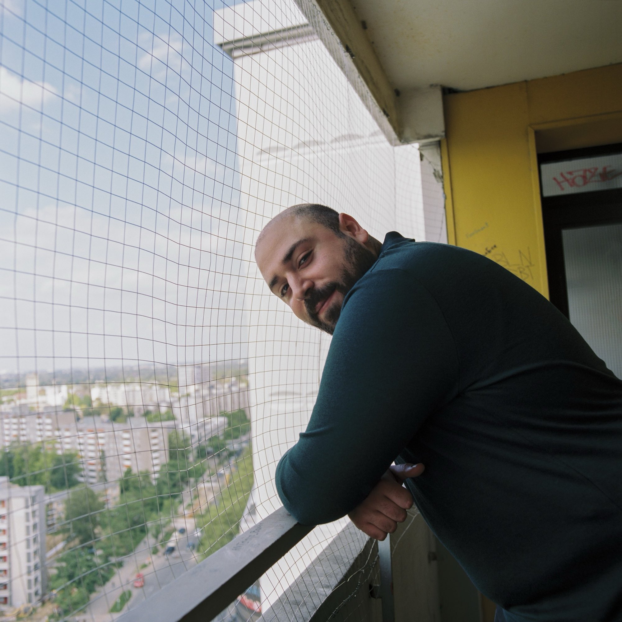 Yurtsever Özdemir auf einem Balkon mit Blick über Neukölln